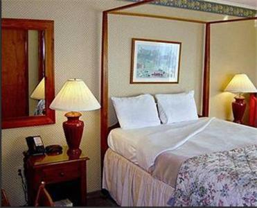 a bedroom with a bed and two lamps and a mirror at West Road Motel in Bennington