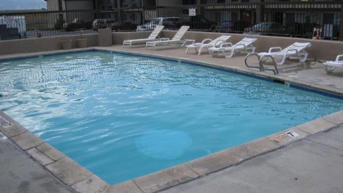 a large swimming pool with lounge chairs and chairs at Discovery Inn in Midvale