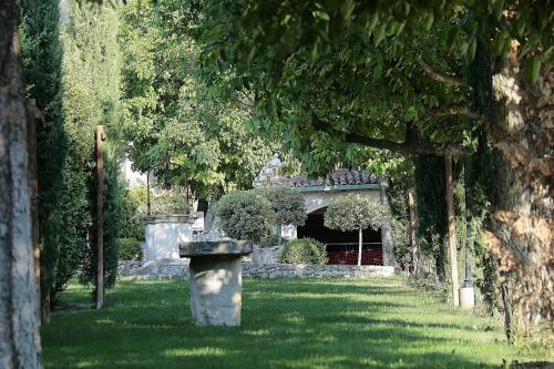 a garden with a stone statue in the grass at Hotel La Valle dell'Aquila in LʼAquila