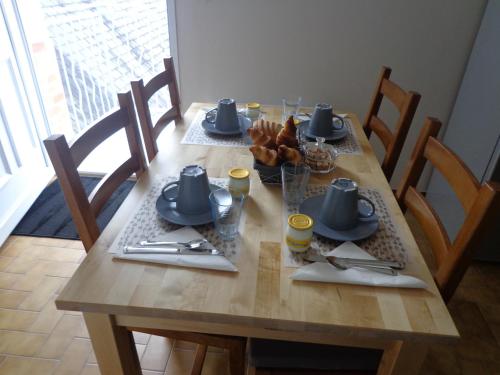 une table en bois avec des assiettes et des ustensiles dessus dans l'établissement La Grille Dorée, à Amboise