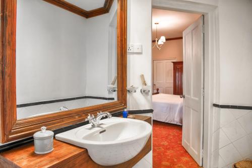 a bathroom with a sink and a mirror at Oatlands by Jetwing in Nuwara Eliya