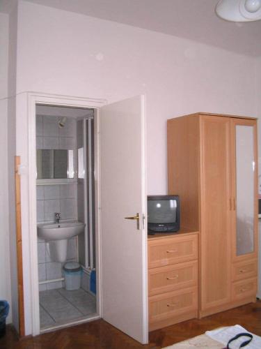 a bathroom with a sink and a television on a dresser at Burg Eger in Eger