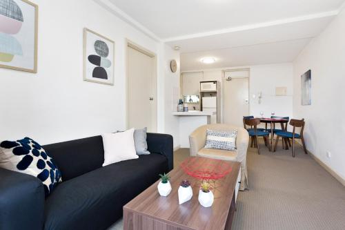 a living room with a black couch and a table at South Perth Executive Apartment in Perth