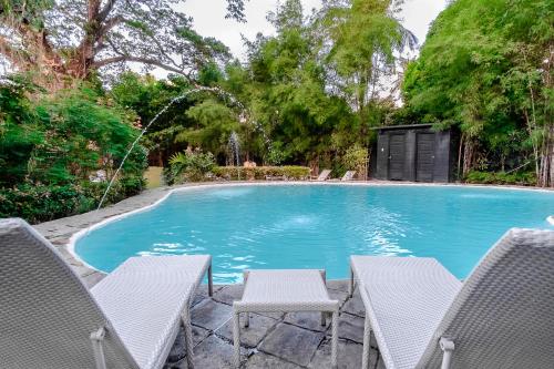 a swimming pool with two chairs and a table at The Henry Hotel Manila in Manila