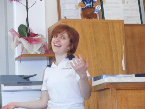 a woman standing in an office with her hand up at Hotel Villa San Donino in Città di Castello