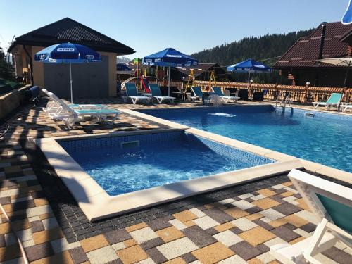 a large swimming pool with chairs and a resort at Hotel Fiesta in Bukovel