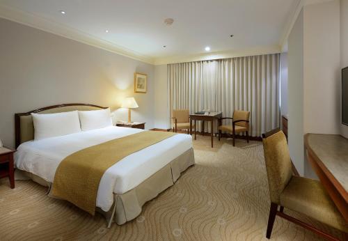 a hotel room with a large bed and a table at Le Midi Hotel Jungli in Zhongli