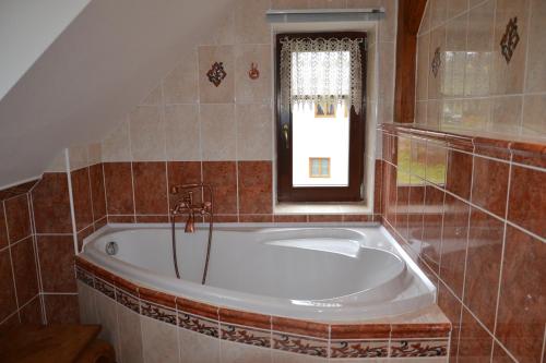 a bath tub in a bathroom with a window at Chalupa 246 in Vrchlabí