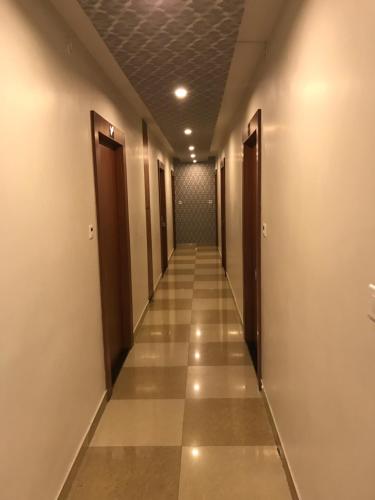 a long hallway with doors and tile floors at Elite Suites MINT Gomti Nagar in Lucknow