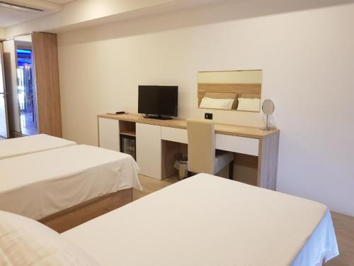 Zimmer mit einem Schreibtisch, einem Computer und einem Bett in der Unterkunft Kosher Hotel Franca in Tivat