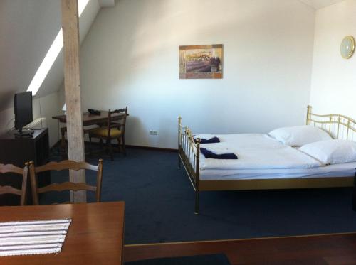 a room with a bed and a dining room with a table at Hotel Zum Bügeleisen in Duisburg