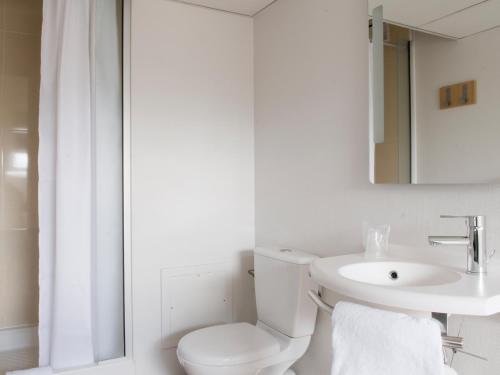 a white bathroom with a toilet and a sink at B&B HOTEL Saint-Quentin in Saint-Quentin