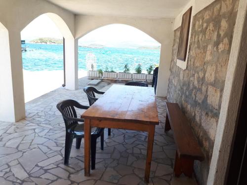 a dining room with a table and chairs and the ocean at Apartments Marinko in Janjina