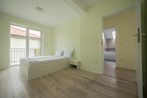 ティミショアラにあるGaga Residence 14の白いベッドルーム(ベッド1台、大きな窓付)