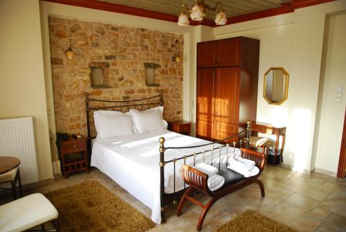 - une chambre avec un grand lit et une chaise dans l'établissement Siarava, à Ioannina