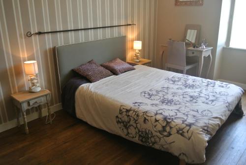 1 dormitorio con 1 cama grande y 2 mesitas de noche en La Ferme Fortin en Gensac-la-Pallue