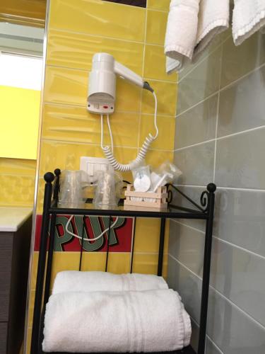 une salle de bains avec une étagère, des serviettes et une lampe dans l'établissement Residenza Murat BB, à Caserte