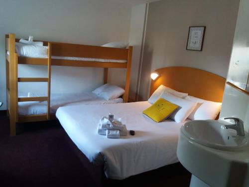 サン・プリエストにあるQuick Palace Lyon Saint-Priestのベッド、シンク、二段ベッドが備わるホテルルームです。