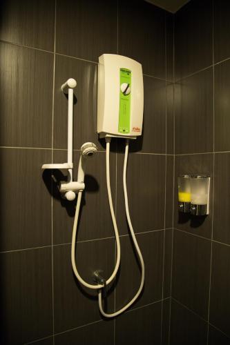 a soap dispenser on a wall in a bathroom at Varinda Hostel in Bangkok
