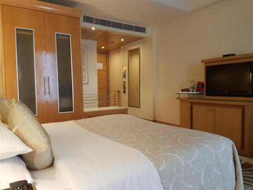 a bedroom with a large bed and a flat screen tv at Park Plaza Gurgaon in Gurgaon