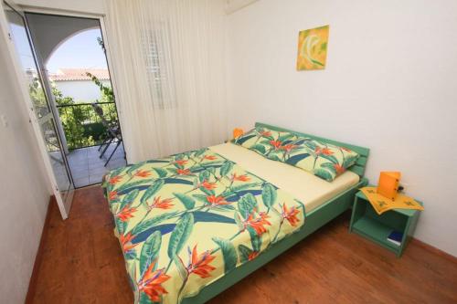 1 dormitorio con 1 cama con colcha de flores en Apartments Plavica en Zečevo