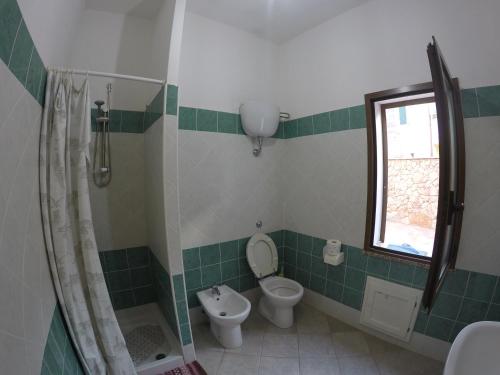 a bathroom with a toilet and a shower and a window at Casa Navarra in Santa Maria Navarrese