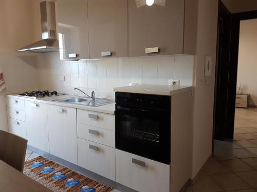 a kitchen with white cabinets and a black stove top oven at EnVie En Rose in Envie