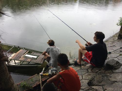 a group of people fishing from a boat in the water at Tam Coc Westlake Homestay in Ninh Binh