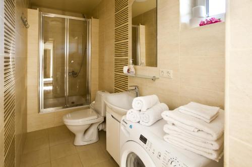 a bathroom with a toilet sink and a washing machine at Апартаменти Маяк in Odesa