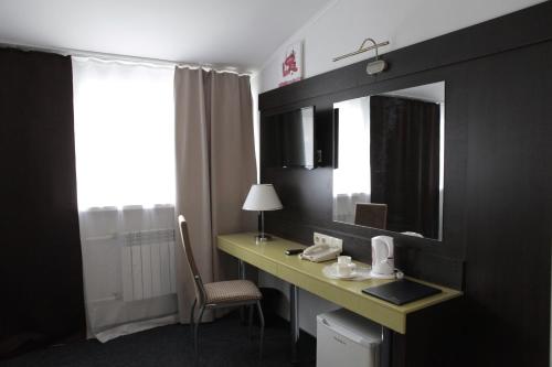 a room with a desk with a mirror and a chair at Avantgarde Hotel & Apart in Kurgan