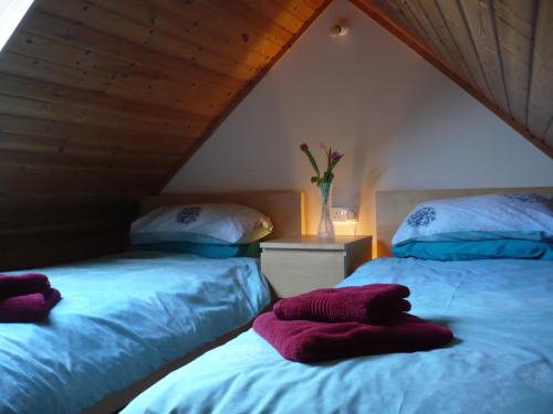 two beds sitting next to each other in a attic at Glas Bheinn Cottage in Luib