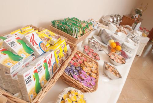ein Tisch voller Körbe mit Keksen und anderen Snacks. in der Unterkunft City Hotel in Casoria