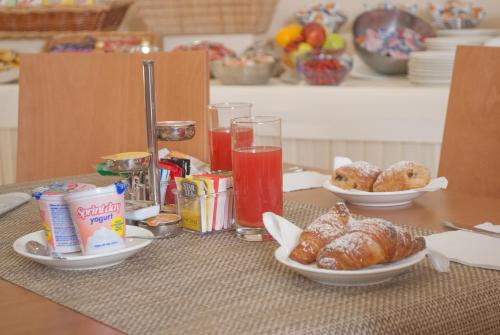 a table with plates of food and drinks and pastries at City Hotel in Casoria