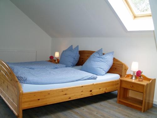 a bedroom with a wooden bed with blue pillows at Schleusenhof Ferienwohnung in Spieka-Neufeld