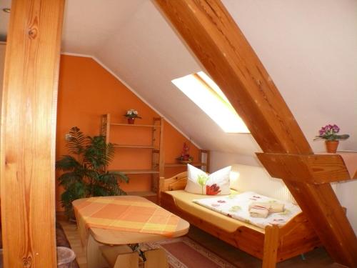 a attic room with a bed and a table at Zur deutschen Eiche in Großschönau