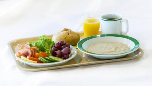 un vassoio con un piatto di cibo e un piatto di frutta e verdura di Kitinrivi B&B a Kannus