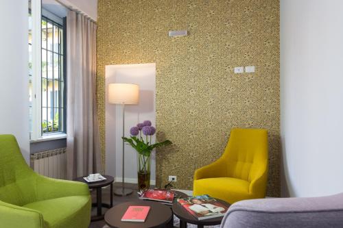 a living room with two chairs and a mirror at Ai Suma Hotel in Milan