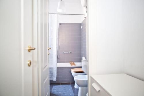 a white bathroom with a toilet and a sink at Viale Trastevere 108 in Rome