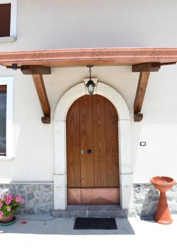 a wooden door of a house with a stone wall at B&B Masseria Cozzi in Lauria Inferiore