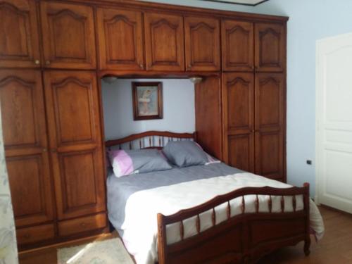 - une chambre avec un lit et des placards en bois dans l'établissement Meublé Tourisme, à Marseille