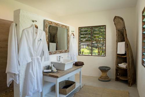 bagno con lavandino e specchio di Chuini Zanzibar Lodge by NEWMARK a Zanzibar City