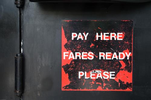 a sign on a wall that says pay here fires ready please at Bed In Bus in Belluno