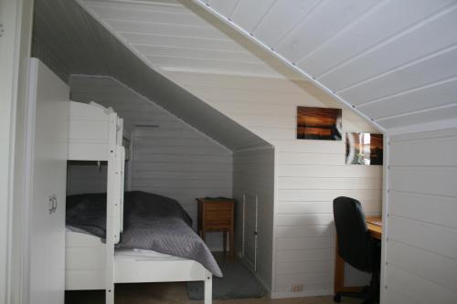 a bedroom with a bunk bed in a attic at Sentralen inn in Andenes