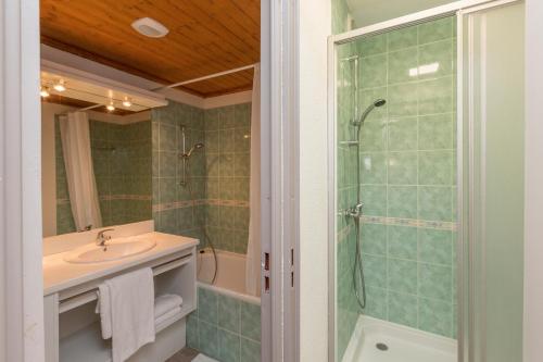 La salle de bains est pourvue d'un lavabo et d'une douche. dans l'établissement Résidence Odalys Les Lumières de Neige, à Valmeinier