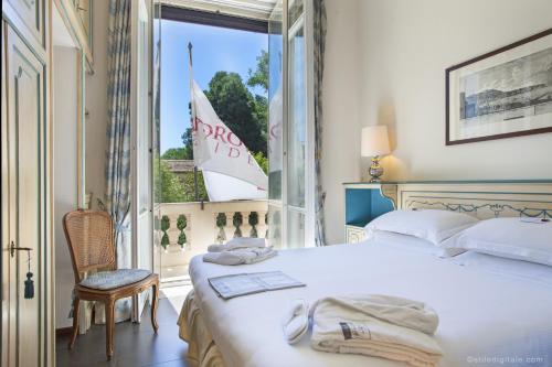 a bedroom with a bed and a window with a sailboat outside at Aldrovandi Residence City Suites in Rome