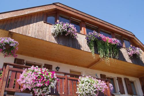 un bâtiment avec des boîtes de fleurs sur son côté dans l'établissement B&B Le Sourire du Lac, à Sévrier