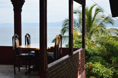 a table and chairs on a porch looking out at the ocean at Reggae Guest House in Tuk Tuk