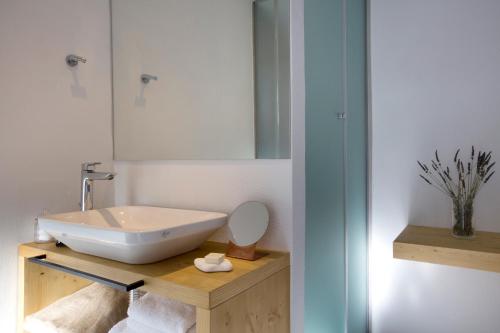 a bathroom with a sink and a mirror at Dreambox Mykonos Suites in Ornos
