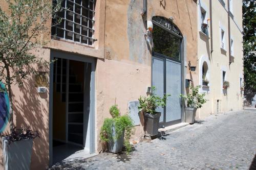 a building with plants in pots on a street at Secret Rhome Loft in Rome