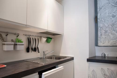 a kitchen with white cabinets and a sink at Secret Rhome Loft in Rome